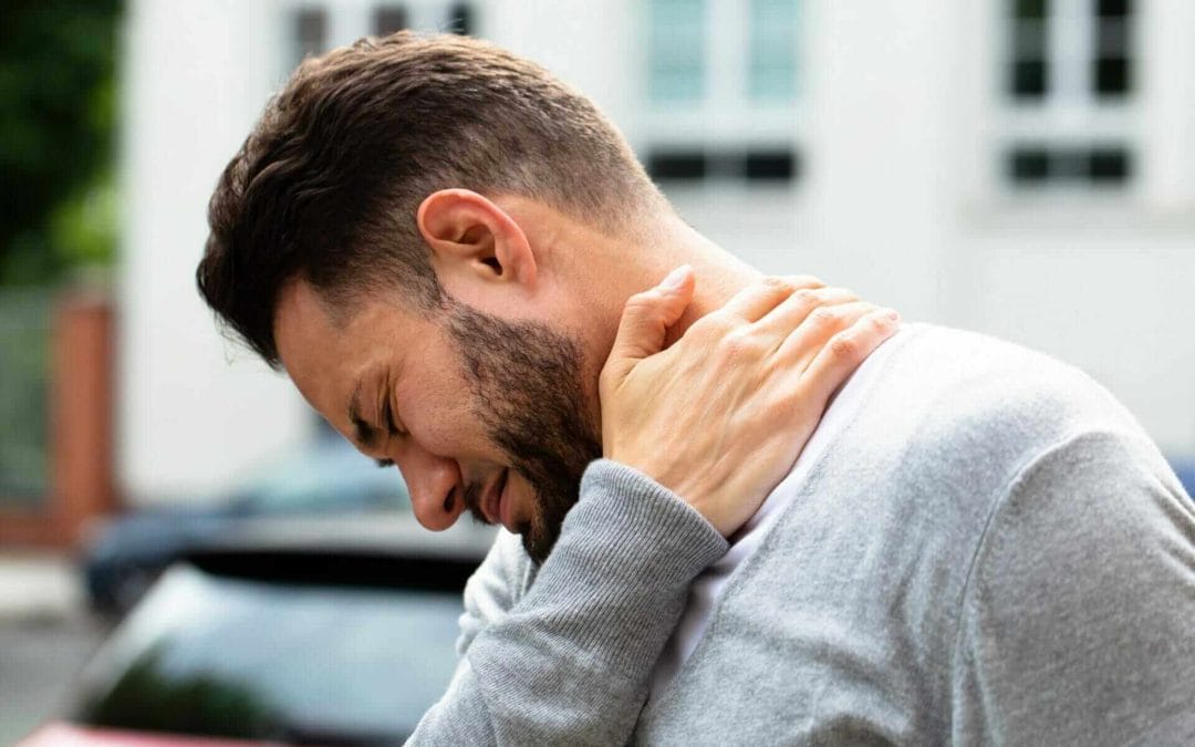 Man holding his neck and shoulder suffering from neck pain